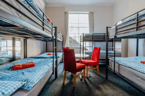 a room with three bunk beds and a table and chairs at Eden Quay Guesthouse Private Rooms in Dublin