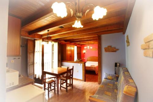 a kitchen and living room with a table and chairs at Apartamentos Aguasaliu in Ponga