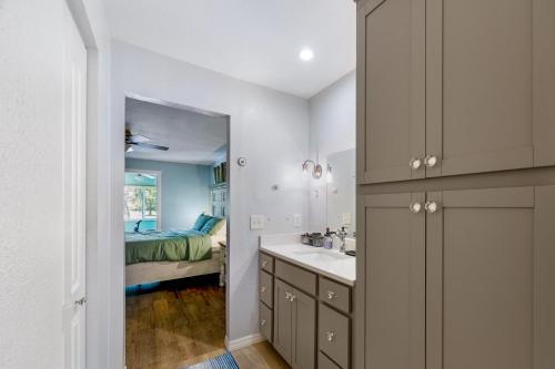 a bathroom with a sink and a bedroom at 3BR Wesley Chapel Retreat with Private Pool - Pet-Friendly - Spacious Parking in Zephyrhills