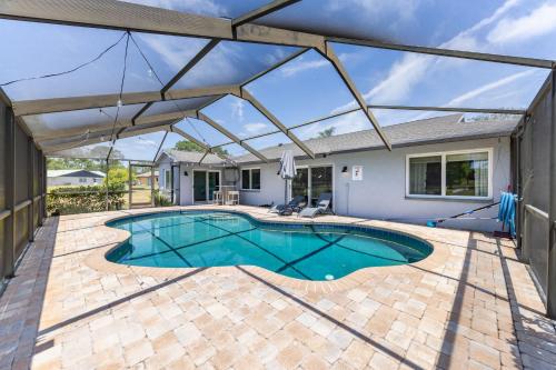 a swimming pool with a large retractable umbrella over it at 3BR Wesley Chapel Retreat with Private Pool - Pet-Friendly - Spacious Parking in Zephyrhills