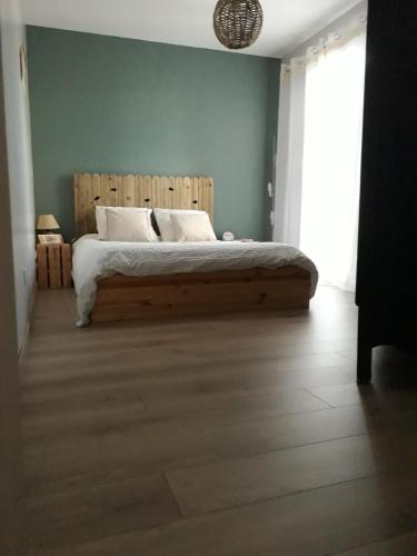 a bedroom with a bed with a wooden headboard at Les Logis de Léa in Saint-Beauzély