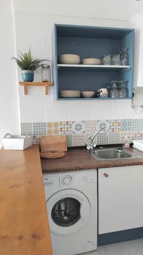 a kitchen with a washing machine and a sink at Appartement vue exceptionnelle sur les canaux in Empuriabrava