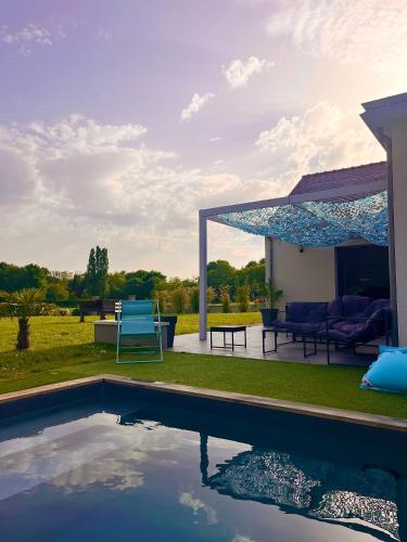 - une piscine dans une cour avec un pavillon dans l'établissement Maison au calme, à Tiercé