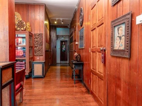 a hallway with wooden walls and a wooden door at Rak Chiang Mai Guesthouse in Chiang Mai