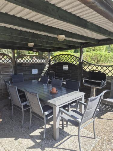 a wooden table and chairs under a pergola at Hotel Panorama in Wees