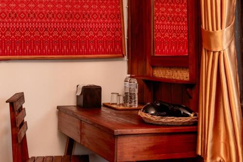 a room with a wooden table with a microwave at Rak Chiang Mai Guesthouse in Chiang Mai