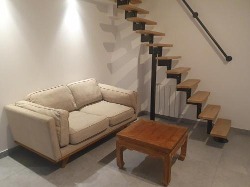 un salon avec un canapé et un escalier dans l'établissement Chez Bastien, à Carqueiranne