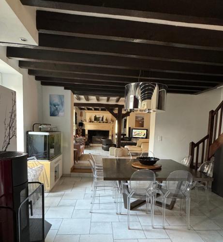 une cuisine et une salle à manger avec une table et des chaises dans l'établissement Lou d'Ange - Maison de campagne, à Achères