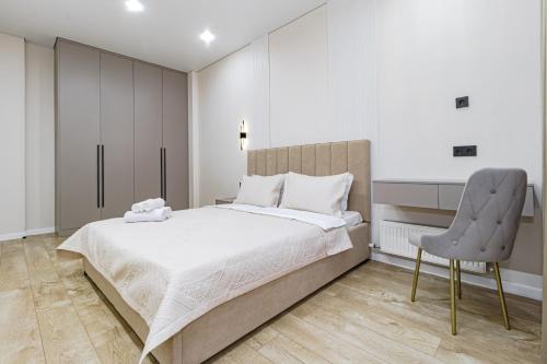 a bedroom with a large bed and a chair at Vivenda in Astana