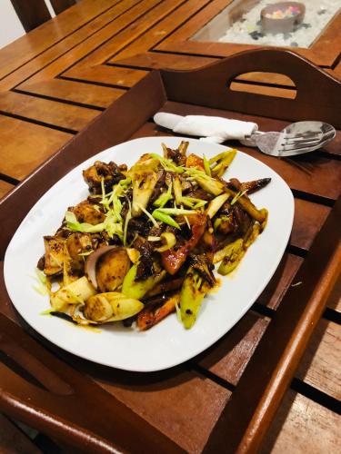 a white plate of food on a table at Singhe Holiday Bungalow in Nikawatawana