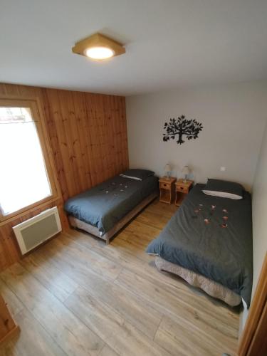 une chambre avec deux lits et une fenêtre dans l'établissement La Givrine, à Val-des-Prés