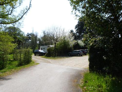 a dirt road with cars parked in a driveway at Appartement familial dans un château avec piscine chauffée, proche plages et sites du Golfe du Morbihan in Baden