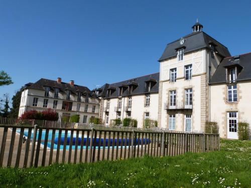 a large building with a fence in front of it at Appartement familial dans un château avec piscine chauffée, proche plages et sites du Golfe du Morbihan in Baden