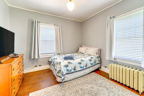 a bedroom with a bed and a tv and windows at 9 Mi to New River Gorge Spacious Retreat with Porch in Glen Jean