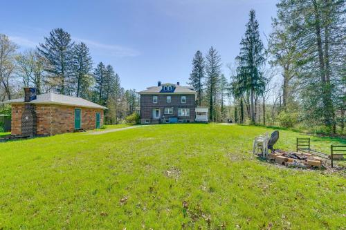a large house on a green field with a building at 9 Mi to New River Gorge Spacious Retreat with Porch in Glen Jean