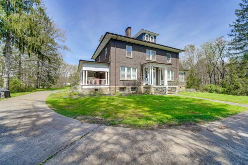 a large brick house on a street with a driveway at 9 Mi to New River Gorge Spacious Retreat with Porch in Glen Jean