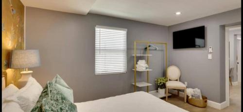 a bedroom with a bed and a window and a chair at Lytle Palm Villa in West Palm Beach
