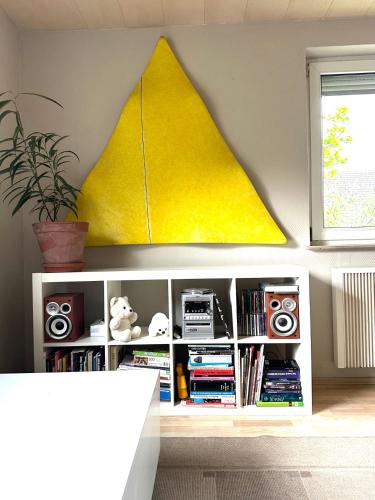 a book shelf with a yellow triangle on the wall at RIO INN in Großbottwar