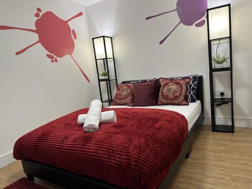a bedroom with a bed with a red blanket at Peaceful detached home with private outdoor space in Stone Grove