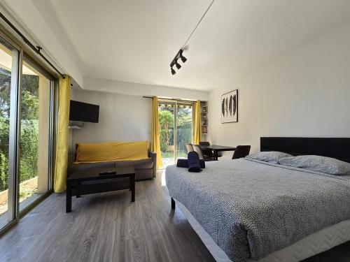 une chambre avec un lit, une chaise et un bureau dans l'établissement Charmant Studio avec jardin - Calme - Proche plage, à Cagnes-sur-Mer