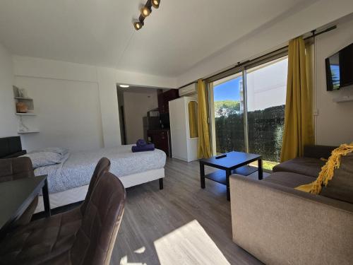 un salon avec un lit et un canapé dans l'établissement Charmant Studio avec jardin - Calme - Proche plage, à Cagnes-sur-Mer