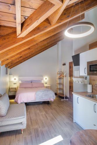 a bedroom with a bed and a wooden ceiling at El Rincón de Andrea Estudios in Biescas