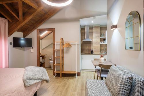 a bedroom with a bed and a table and a kitchen at El Rincón de Andrea Estudios in Biescas
