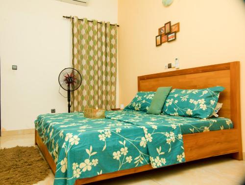 コトヌーにあるDares Salaamの青い掛け布団が敷かれたベッドのある寝室