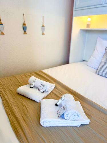 deux serviettes sur un lit dans une chambre dans l'établissement Le Maritime - Proche plage, Wifi, à Vaux-sur-Mer