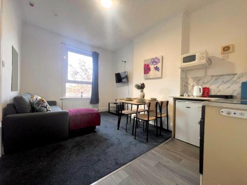 a living room with a couch and a kitchen with a table at Cozy one bedroom flat sleeps 5 Skegness F6 in Skegness