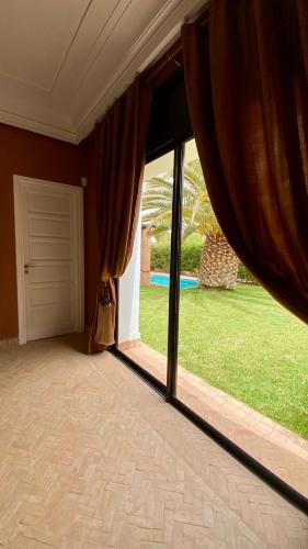 a room with a large sliding glass door with a yard at Luxueuse villa Proche Agadir et Taroudant pour 6 pers Piscine Privée sans vis à vis in Agadir