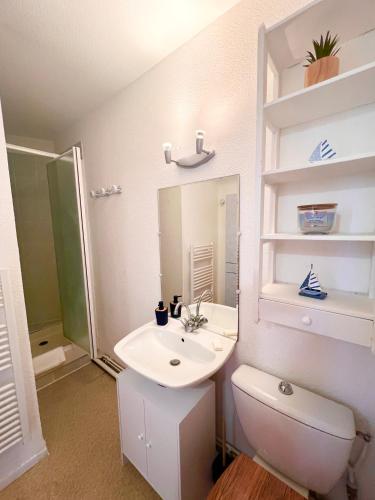 une salle de bain avec un lavabo, des toilettes et un miroir dans l'établissement Le Maritime - Proche plage, Wifi, à Vaux-sur-Mer