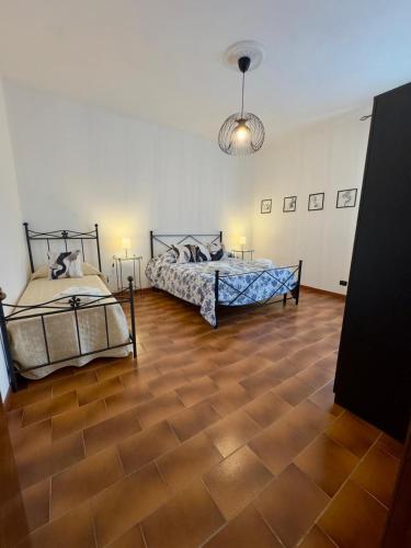 two beds in a room with wooden floors at Casita in Radda in Chianti