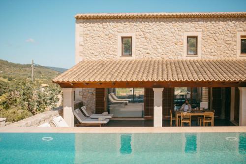 a villa with a swimming pool next to a house at Ca'n Beneït in Binibona