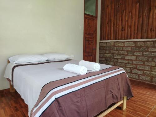 a bedroom with a bed with two towels on it at Lucmabamba Lodge in Santa Teresa