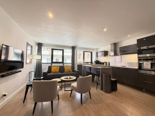 une cuisine et un salon avec un canapé et une table dans l'établissement Centre-ville - grand T3 moderne - parking, à Toulouse