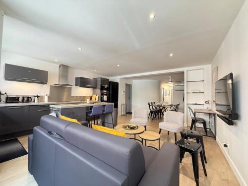 un salon avec un canapé bleu et une cuisine dans l'établissement Centre-ville - grand T3 moderne - parking, à Toulouse