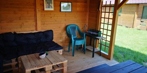 a porch of a cabin with a couch and a desk at Rentyny Rodzinny dom wypoczynkowy nad jeziorem in Rentyny