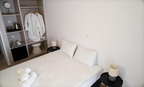 a white bed in a room with a closet at Sandy Beach in Agia Marina Aegina