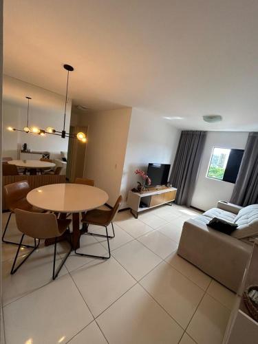 a living room with a table and a couch at Apartamento próximo a praia in Maceió