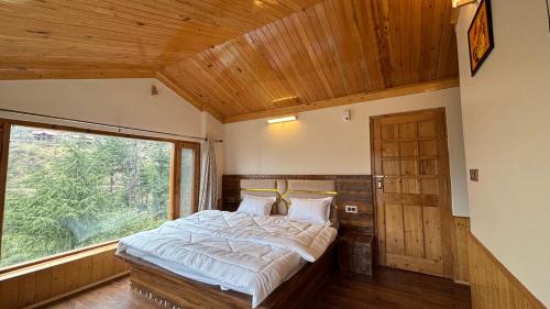 a bed in a room with a large window at Kaushalya Homes in Shimla