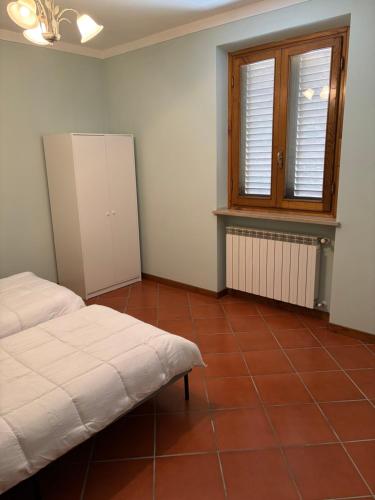 a bedroom with a bed and a window and a tiled floor at La casa del Geko rosa in Lucca