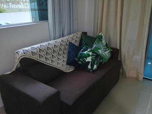 a couch with pillows on it with a window at Cobertura com vista pro mar in Cabo de Santo Agostinho