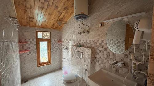 a bathroom with a tub and a sink and a mirror at Kaushalya Homes in Shimla