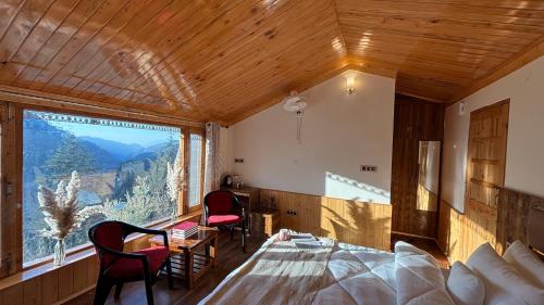 a bedroom with a bed and a large window at Kaushalya Homes in Shimla
