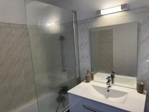 une salle de bain avec un lavabo et une douche avec un miroir dans l'établissement Studio avec balcon sur Talence, à Talence