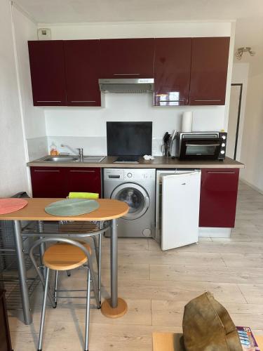 une cuisine avec une table, une cuisinière et un lave-vaisselle dans l'établissement Studio avec balcon sur Talence, à Talence