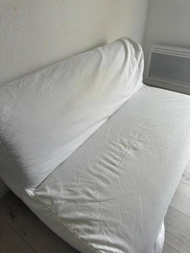 - un lit non aménagé avec des draps blancs dans une chambre dans l'établissement Studio avec balcon sur Talence, à Talence