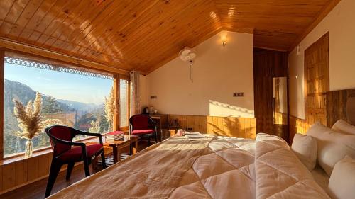 a bedroom with a large bed and a large window at Kaushalya Homes in Shimla