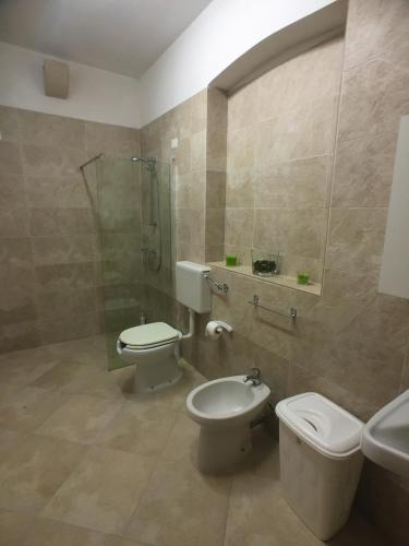 a bathroom with two toilets and a shower and a sink at Masseria Bosco Mazza in Melendugno